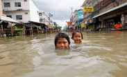 Children play in flooded street north of Bangkok, Sept 12, 2011/Sukree Sukplang, Reuters, The Atlantic (10/12/11)