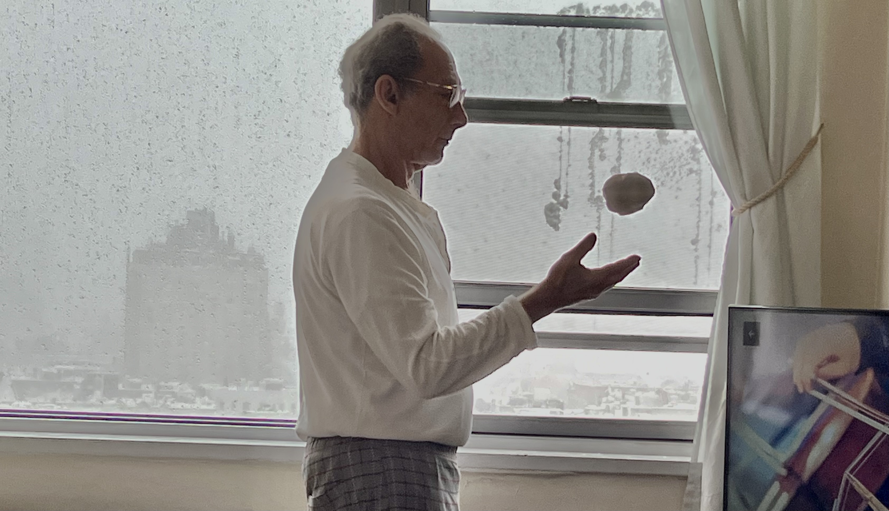 Marc tests a snowball made of snow scooped off our window ledge, Greenwich Village NYC, 11:37 a.m., Monday, February 23 / Gini Kopecky Wallace